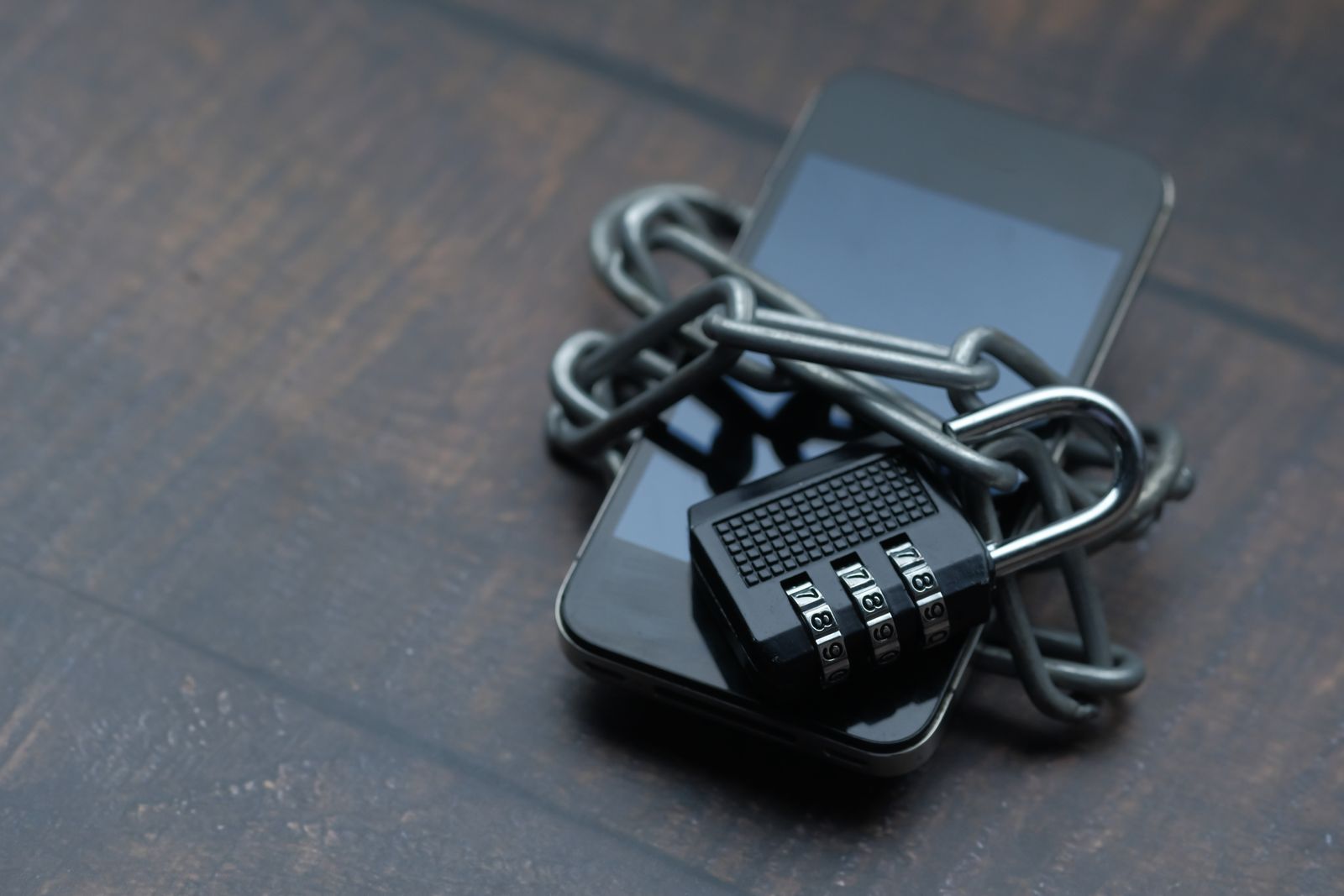 Celular envuelto en una cadena con candado, símbolo de seguridad digital
