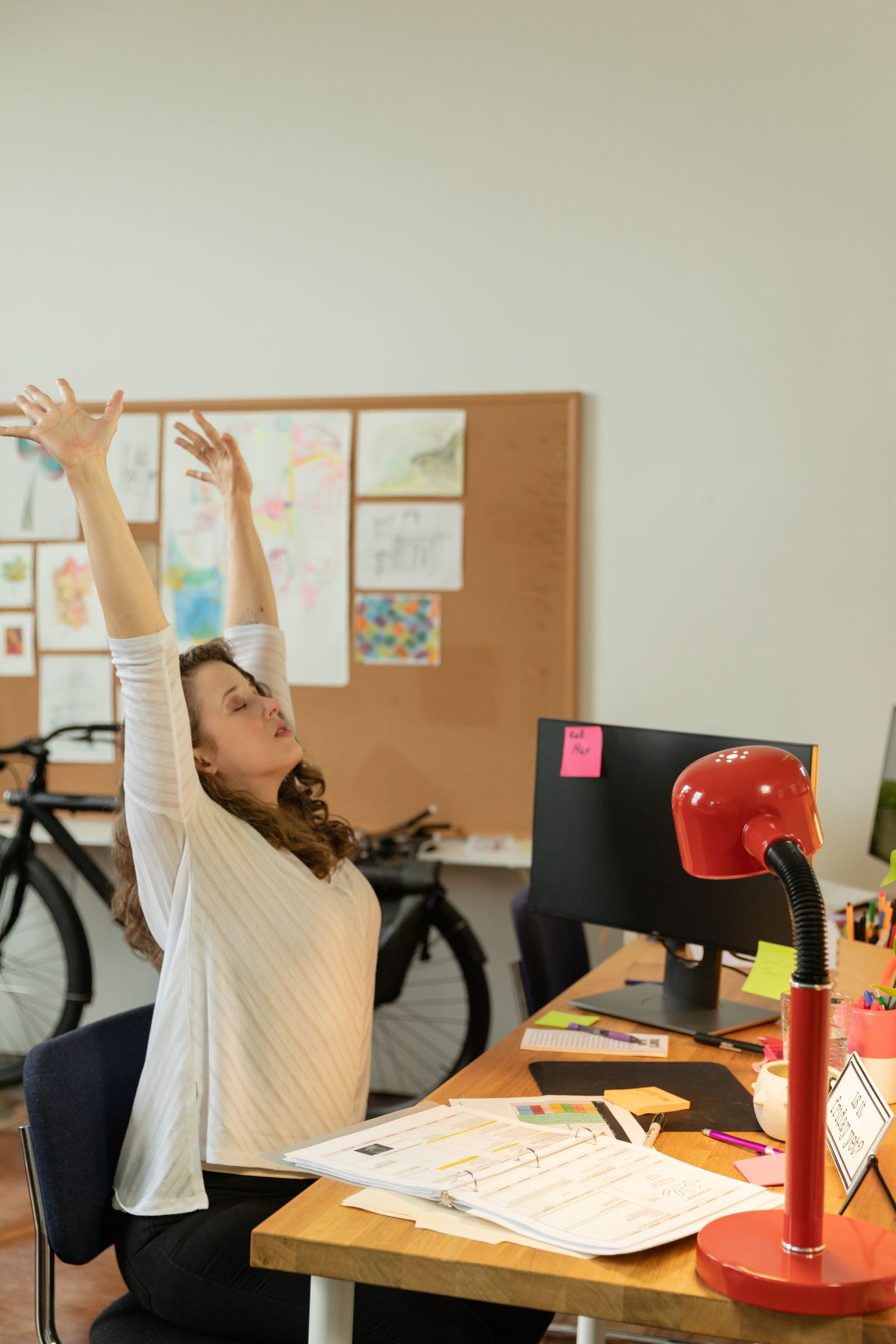 Mujer estirándose en su escritorio durante una pausa de trabajo